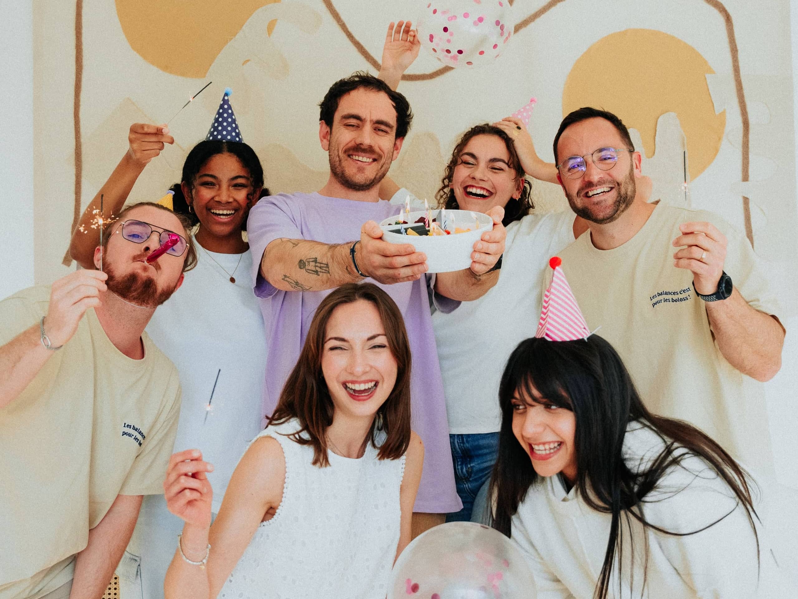 Photo pour les 2 ans d'anniversaire de maju où tous les employés de maju fêtent ce moment avec un bol maju rempli, avec des bougies par dessus.